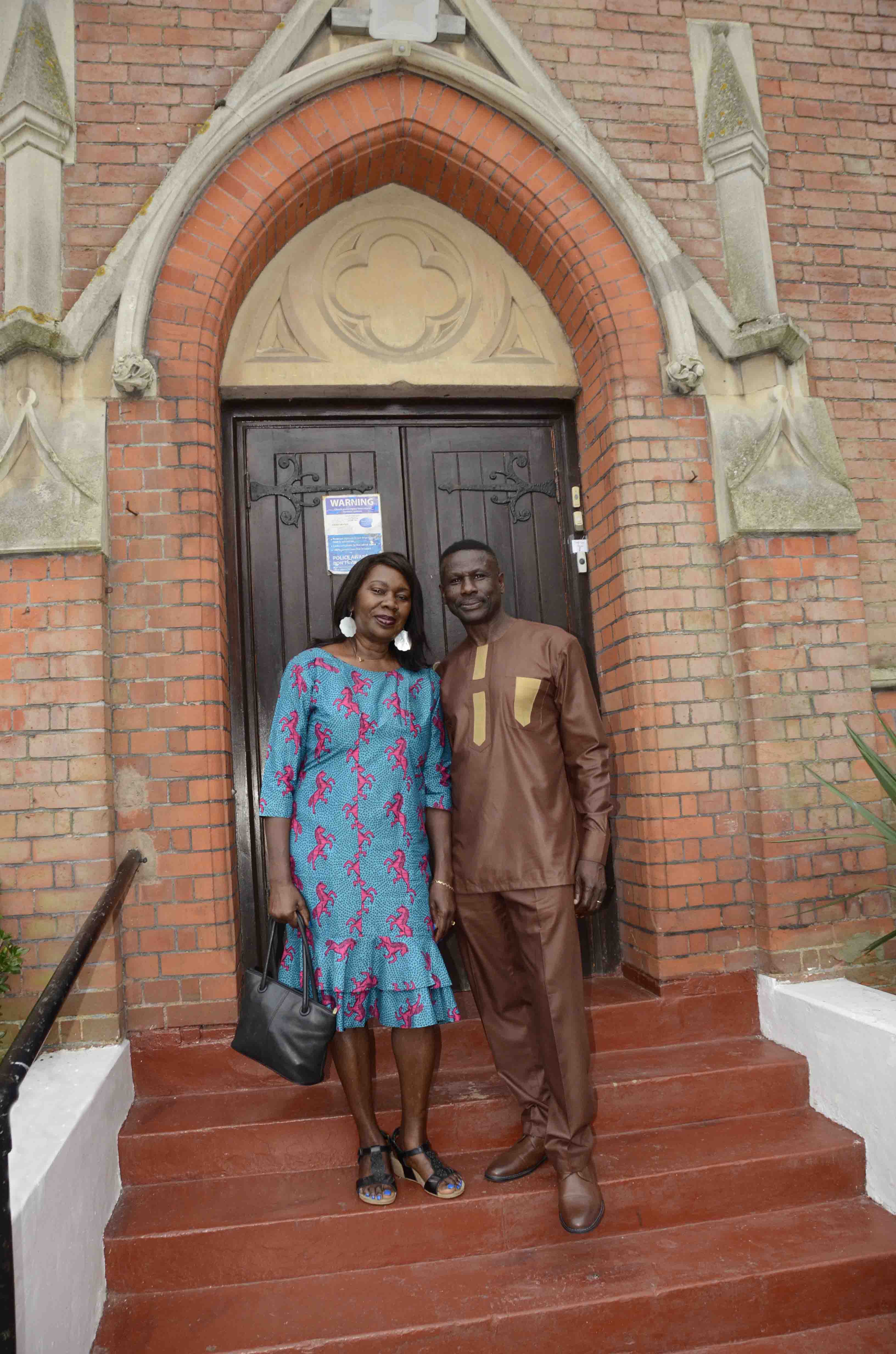 Pastor Cornelius Mereweather-Thompson and Mrs Mereweather-Thompson on the front steps of Harlesden Baptist Church